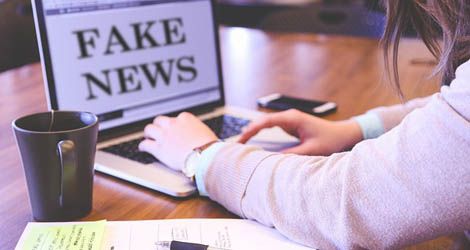 Autor zdjęcia: Pixabay Osoba siedząca przed komputerem na którym wyświetla się komunikat "fake news"