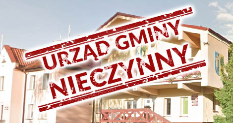 Na pierwszym planie napis urząd gminy - nieczynny. W tle budynek Urzędu Gminy w Jonkowie