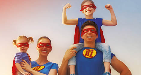 Rodzina czeteroosobowa na kolorowym tle w ubiorach supermana