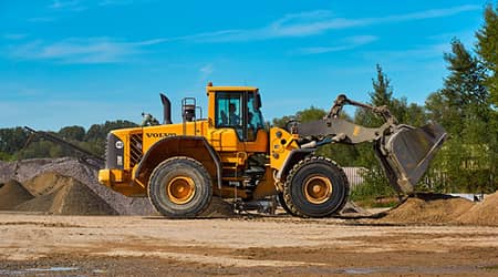 Zdjęcie przedstawiające ładowarkę kołową podczas pracy.