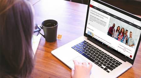 Zdjęcie kobiety siedzącej przed laptopem.