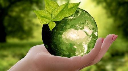 Źródło grafiki: Pixabay Grafika z kulą ziemską na dłoni. W tle natura