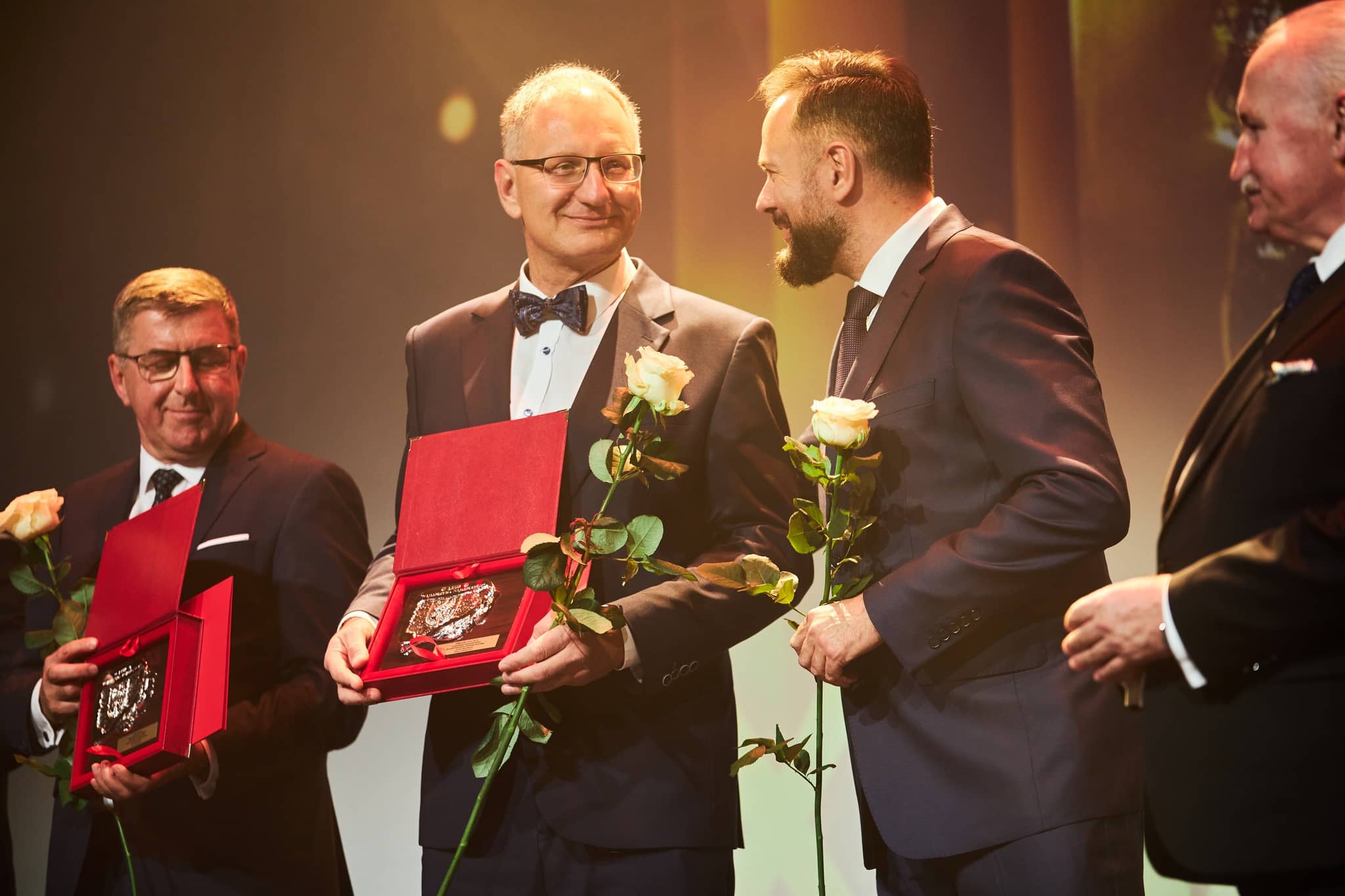 Zdjęcie czterech mężczyzn stojących na scenie podczas wręczania wyróżnień.