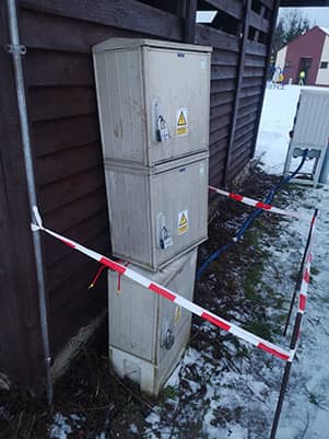 zdjęcie uszkodzonych skrzynek energetycznych otoczonych taśmą ostrzegawczą