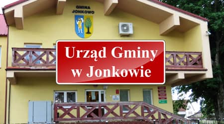 Źródło grafiki: UG Jonkowo. Zdjęcie budynku urzędu gminy w Jonkowie. Na pierwszym planie tabliczka z napisem urząd gminy.